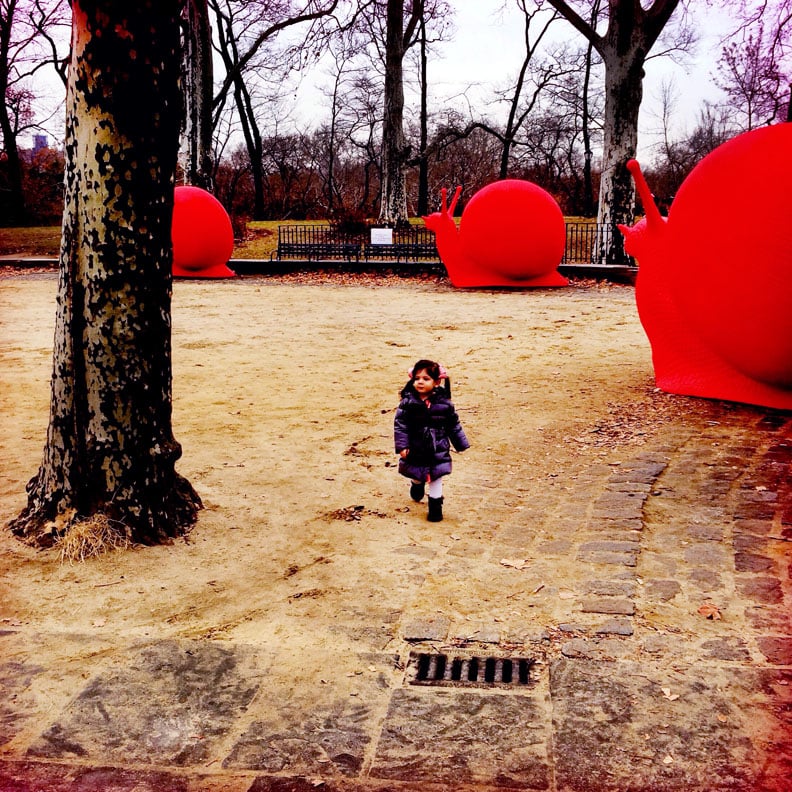 Little girl and red snails in Central Park