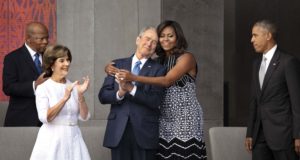 WASHINGTON, D.C. -- SEPT 24: First Lady Michelle Obama hugs former President George W. Bush, with Congressman John Lewis, former First Lady Laura Bush, and President Barack Obama at the opening of the National Museum of African American History and Culture. September 24, 2016, Washington, D.C.  (Photos by David Hume Kennerly) Photographed on assignment for Bank of America.