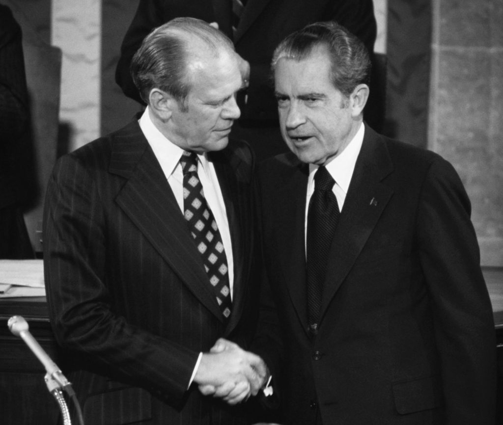 WASHINGTON DC  - DECEMBER 6: (NO U.S. TABLOID SALES) Gerald R. Ford shakes hands with U.S. President Richard M. Nixon (r) during Ford's Vice President Inauguration in the House Chamber, U.S. Capitol on December 6, 1973 in Washington, DC.  The oath was administered by Chief Justice Warren Burger of the Supreme Court. James Eastland, President pro Tempore of the Senate (back) attends ceremony. Ford was appointed by President Richard M. Nixon after Vice President Spiro Agnew resigned his office while under criminal investigation from his time as an office holder in Maryland. (Photo by David Hume Kennerly/Getty Images)
