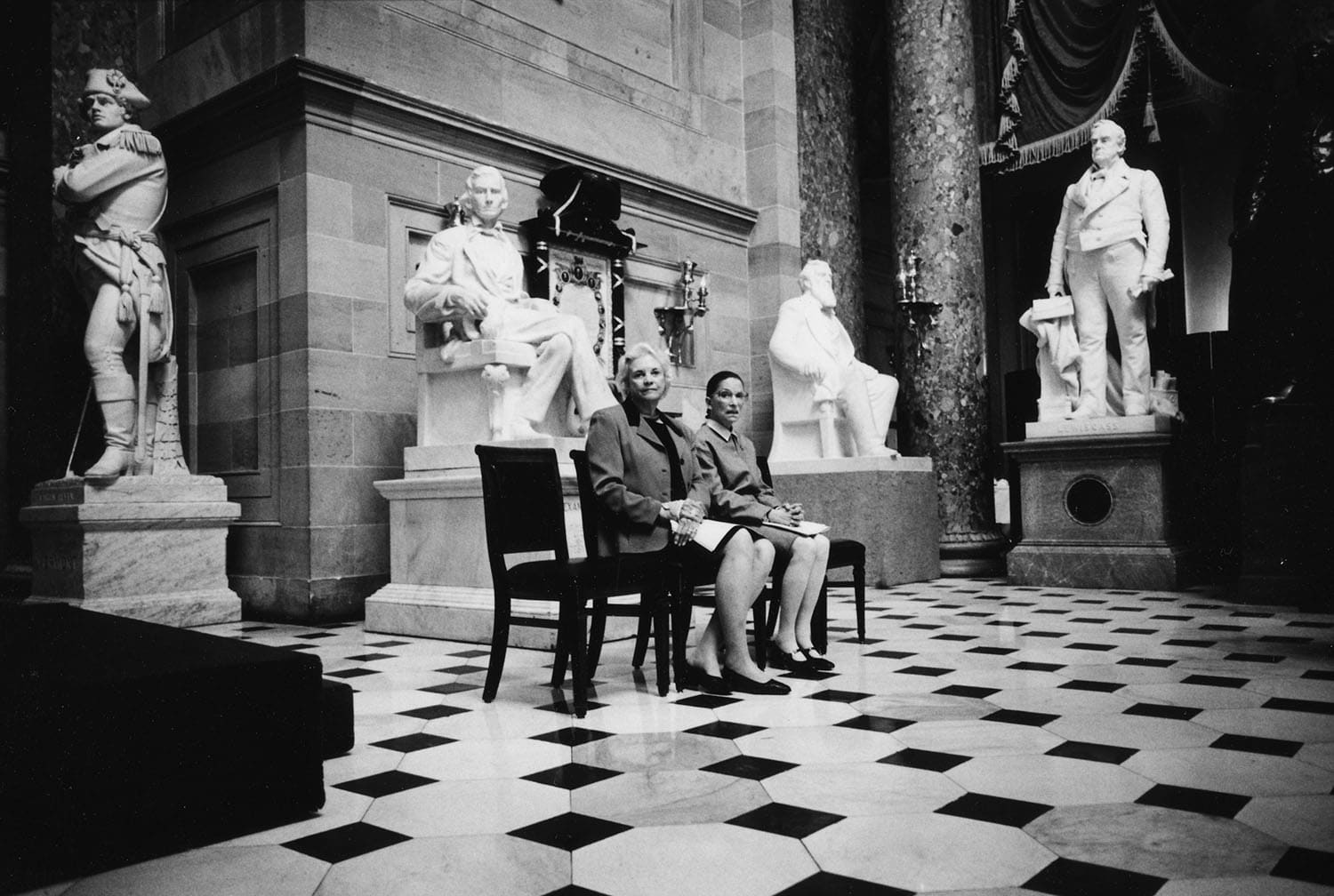Justices O’Connor and Ginsburg surrounded by statues of men in the U.S. Capitol, 2001