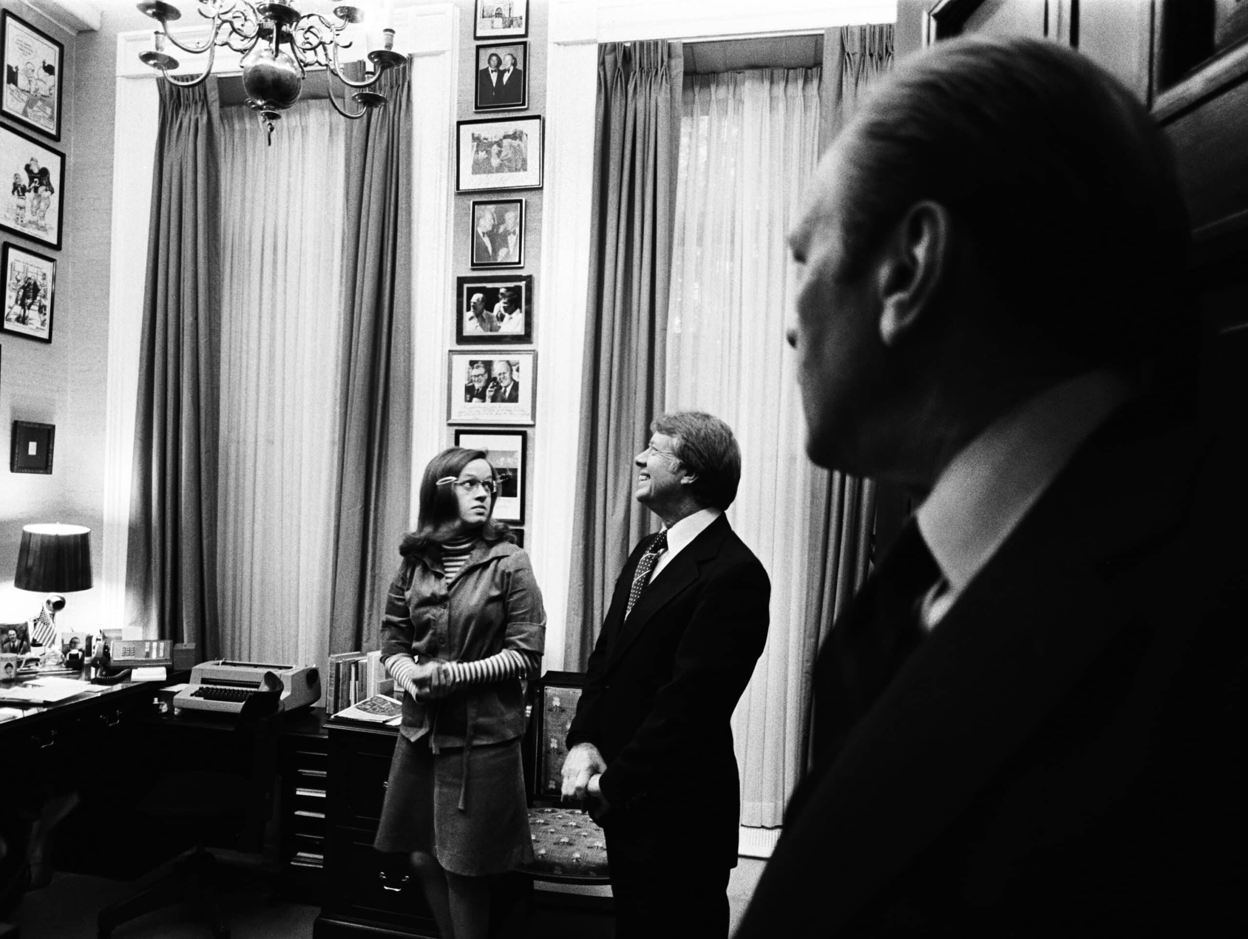 President Ford shows Carter his hideaway as his secretary Dorothy Downton observes the president-elect 